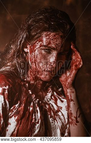 Spooky portrait of a poor innocent girl drenched in blood standing weak in a dark gloomy castle. Horror, thriller. Halloween. Vampires.