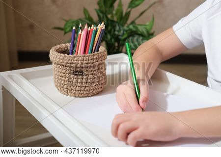 Kid's Hands Drawing With Color Pencils And Woven Wicker Basket For Stationery Storage. Hand Made Bas