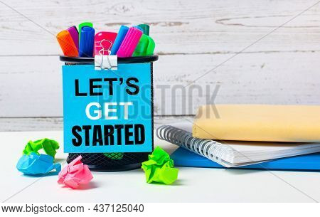 Against A Light Background Of A Wooden Wall, There Is A Glass With Colored Markers, Crumpled Bright 