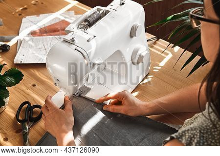 Seamstress Sewing The Linen Fabric On The Sewing Machine In Small Studio. Fashion Atelier, Tailoring