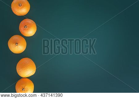 Citrus Tripic Fruit. Healthy Food Vitamins. Tangerines On A Green Background.