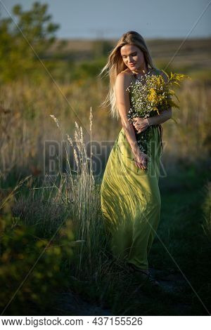A Young Herbalist In Love With A Bouquet Of Herbs Strolls Romantically Through The Meadows.