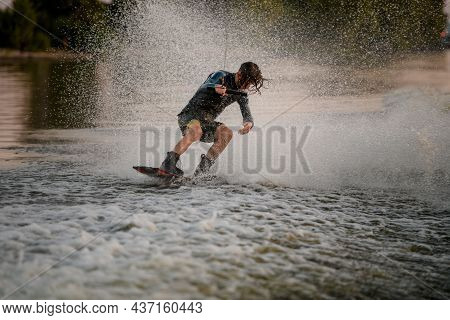 Beautiful View Of Male Wakeboarder Riding Wakeboard On And Lots Of Splashes Around Him