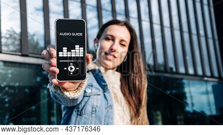 Audio Excursion Online App On Digital Mobile Smartphone. Happy Young Student Woman Holding Phone Lis