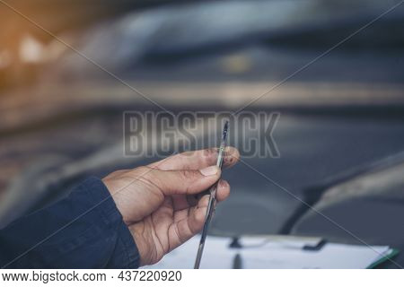 Car Mechanic Man Hand Checking Dipstick Engine Oil Car Mechanical On Site Service. Close Up Hand Man
