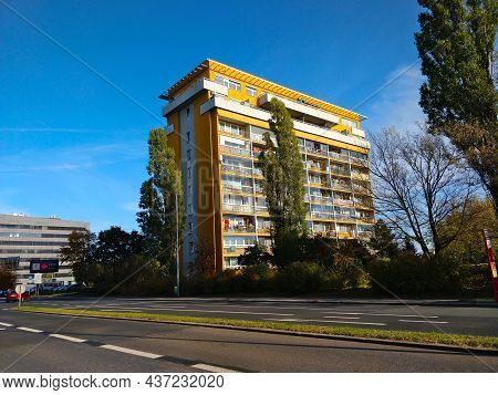 Prague, Czech Republic - October 24, 2021: Tall Orange Block Of Flats Surrounded With Trees And Wide