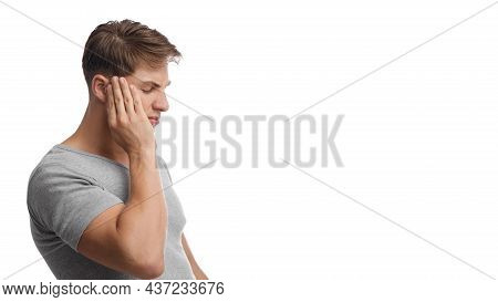 Despaired Millennial European Man Suffering From Headache, Presses Hand To Temple