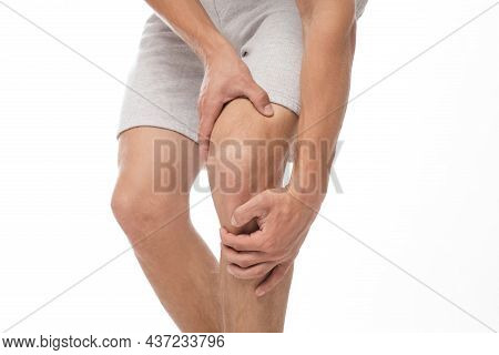 Cropped Millennial European Male Athlete Suffering From Knee Pain, Presses His Hand To Sore Spot