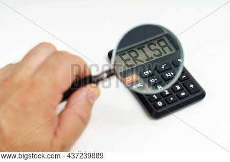 Business And Finance Concept. A Man Looks Through A Magnifying Glass At A Calculator On The Screen O