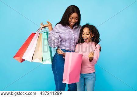 African American Woman And Girl Looking Iside Shopping Bags