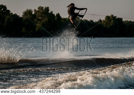 Energy Man Holds Rope And And Jumping High On Splashing Wave On A Wakeboard