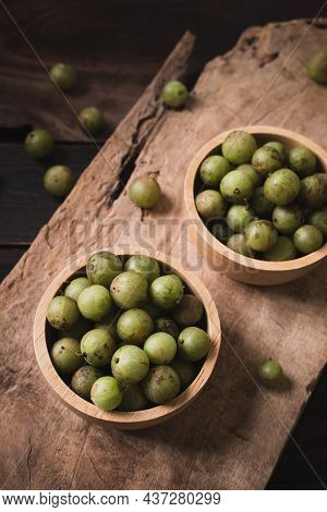 Wild Indian Gooseberry Or Amla In A Bowl On Wooden Background, Fruit Tree In Asia Use In Various Cui