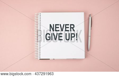 Never Give Up Text On The Notebook With Pen On The Pink Background
