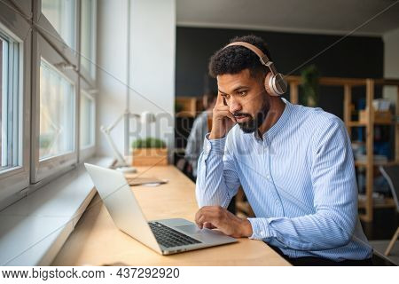 Young African-american Teacher With Headset And Laptop Indoors In Staffroom.