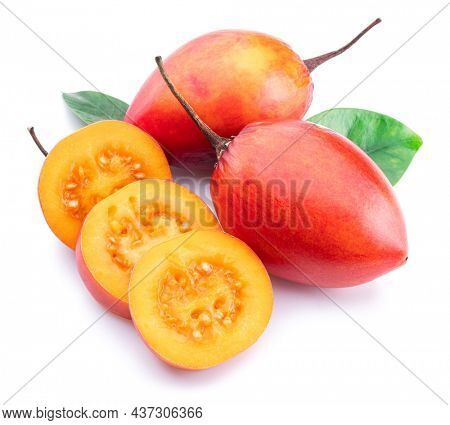 Ripe tamarillo fruits with slices and tamarillo leaves isolated on a white background.