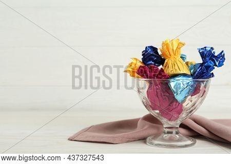 Candies In Colorful Wrappers On White Wooden Table, Space For Text