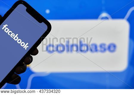 Tashkent, Uzbekistan - 22 October, 2021: Hand Holds Mobile Phone With Facebook Logo Over Coinbase Lo