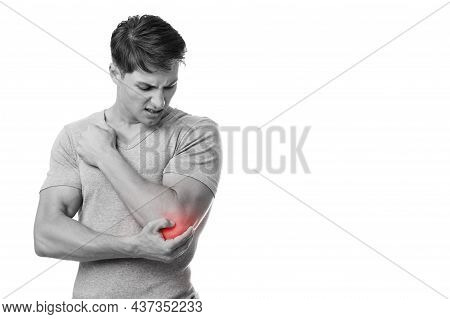 Disappoint Young European Man Suffering From Elbow Pain, Presses Hand To Sore Spot, With Red, Monoch