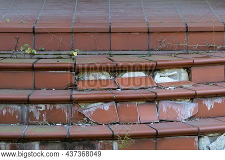 Damaged House Staircase Or Stairs With Broken Tiles Over Concrete Steps. Close Up