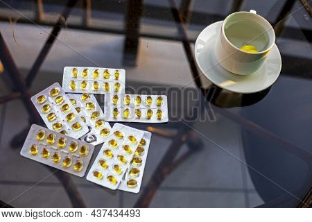 Blurred Cup Of A Drink With Lemon And Vitamin D Blisters In The Morning On The Balcony In The Hotel,