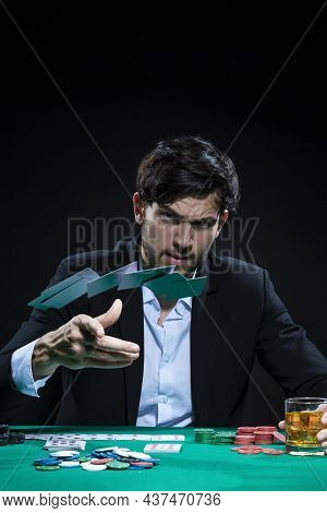 Casino Concepts. Serious Handsome Caucasian Young Pocker Player Throwing Cards To Win At Pocker Tabl