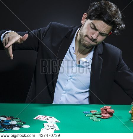 Emotional Handsome Caucasian Brunet  Pocker Player At Pocker Table With Chips And Cards While Playin