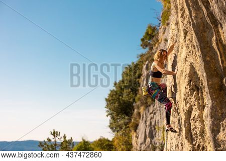 The Girl Climbs The Rock. The Climber Trains On Natural Terrain.  A Woman Overcomes A Difficult Clim