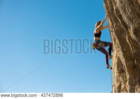 The Girl Climbs The Rock. The Climber Trains On Natural Terrain.  A Woman Overcomes A Difficult Clim