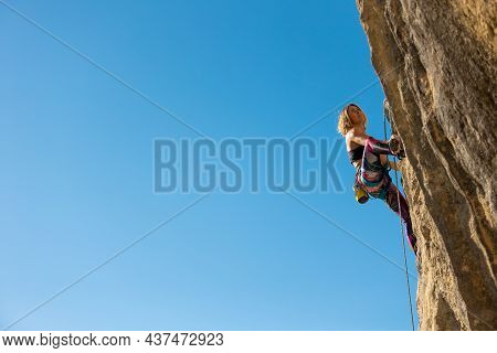 The Girl Climbs The Rock. The Climber Trains On Natural Terrain.  A Woman Overcomes A Difficult Clim