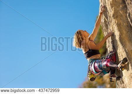 The Girl Climbs The Rock. The Climber Trains On Natural Terrain.  A Woman Overcomes A Difficult Clim