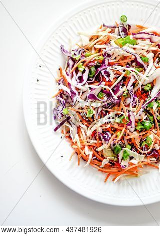 Coleslaw Cabbage Salad With Cabbage, Carrots, Herbs And Sesame Seeds On A White Plate. Healthy Eatin