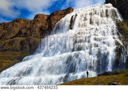 Person Standing At The Dynjandi Waterfall, Also Known As Fjallfoss, Located On The Westfjords Penins