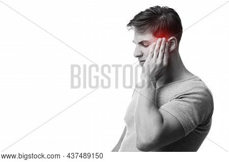 Sad Young European Guy Suffering From Headache, Press Hand To Head, Monochrome Photo