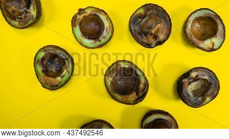 Bad Avocado Halves Close Up On Yellow Background. Food Fruits Cannot Be Eaten. Overripe Avocado Frui
