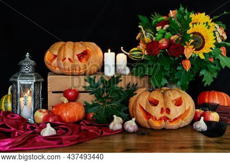 Halloween Pumpkins, Candles, Garlic And Sunflower On Wooden Table Background. Studio Shot With Scary
