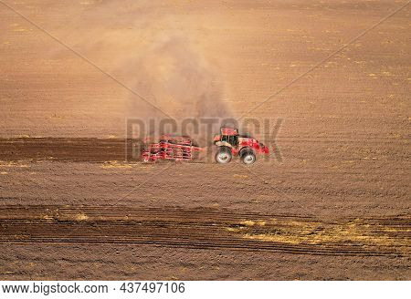 Soil Tillage In Farmers Country. Red Tractor On Cultivating Field Work. Agricultural Tractor On Cult