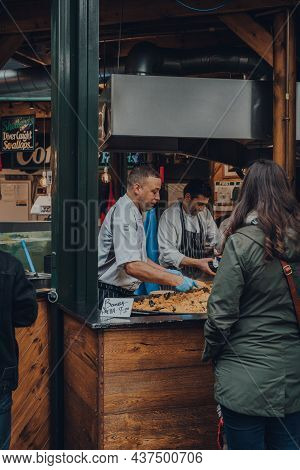 London, Uk - October 17, 2021: Staff Serving Bomba Paella At The Furness Food Hut Stall Inside Borou