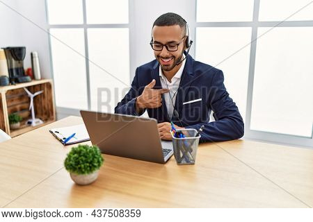 African american young man wearing call center agent headset at the office pointing finger to one self smiling happy and proud 