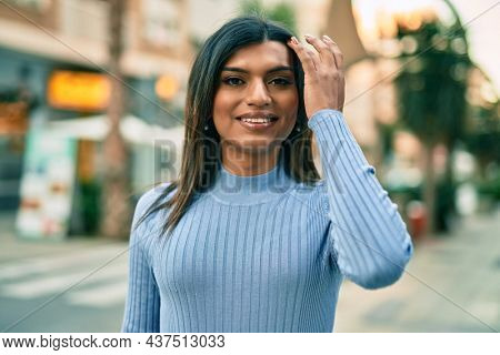 Beautiful hispanic woman smiling confient at the city