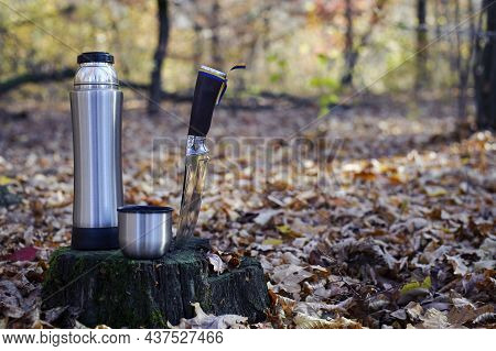 Thermos And Hunting Knife. The Concept Of Tourism, Survival And Hunting In The Autumn In Forest. A T