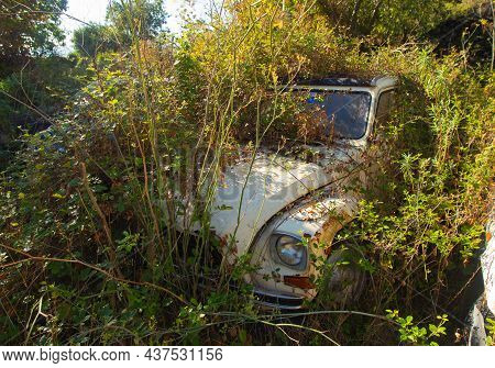 Randazzo, Sicily Italy - 09 24 2021: Remains Of Citroen Dyane In A Grass. Ecological Problem Car Dum