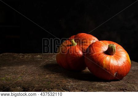 Two Fresh Organic Ripe Potimarron Pumpkins On A Dark Wooden Background, Autumn And Harvesting Concep