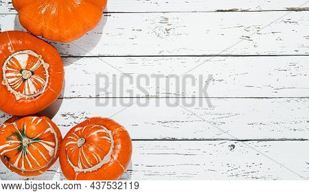 Several Organic Ripe Potimarron Pumpkins On A White Wooden Table, Autumn And Harvesting Concept, Top