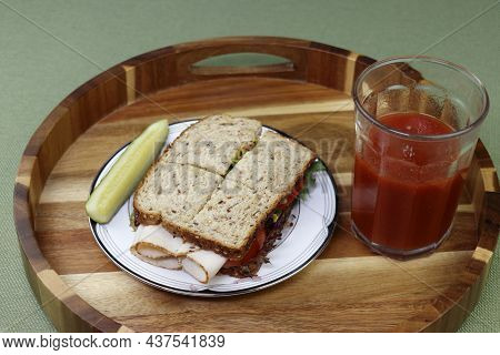On A Round Wood Tray On A Plate Is A Turkey Cold Cut Sandwich With Tomato, Lettuce And Mustard Near 