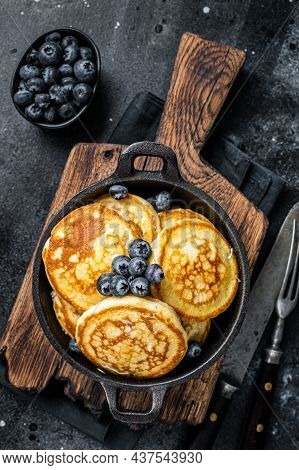 Pancakes With Fresh Blueberries And Maple Syrup In A Pan. Black Background. Top View