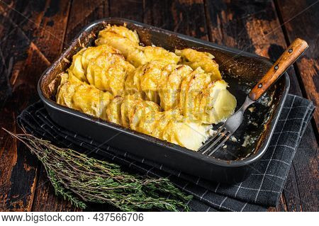 Potato Casserole Gratin Dauphinois In A Baking Dish. Dark Wooden Background. Top View