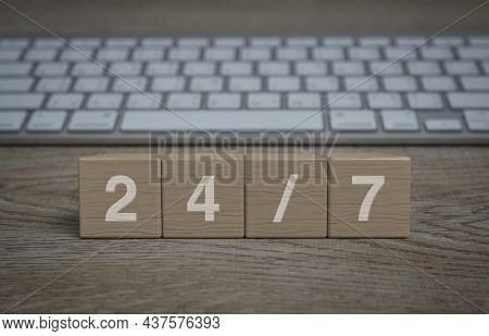 247 Letter On Wood Block Cubes On Wooden Table With Modern Computer Keyboard, Business Full Time Ser