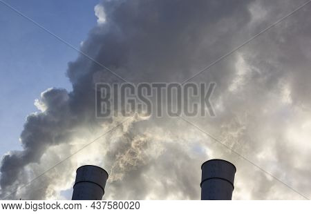Air Pollution By Smoke Coming Out Of Two Factory Chimneys. Close-up From Below Of Smoke Coming Out O