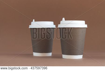 Two Paper Corrugated Coffee Cups With Caps On Brown Background With Copy Space
