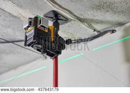 Laser Level Measuring Tool With Visible Green Laser Beam On Wall At Construction Site. Measuring Lev